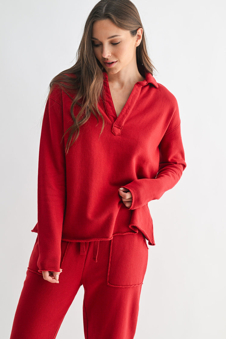 Woman wearing a red long-sleeve Virginia Malibu Vintage Henley Tee with matching sweatpants.