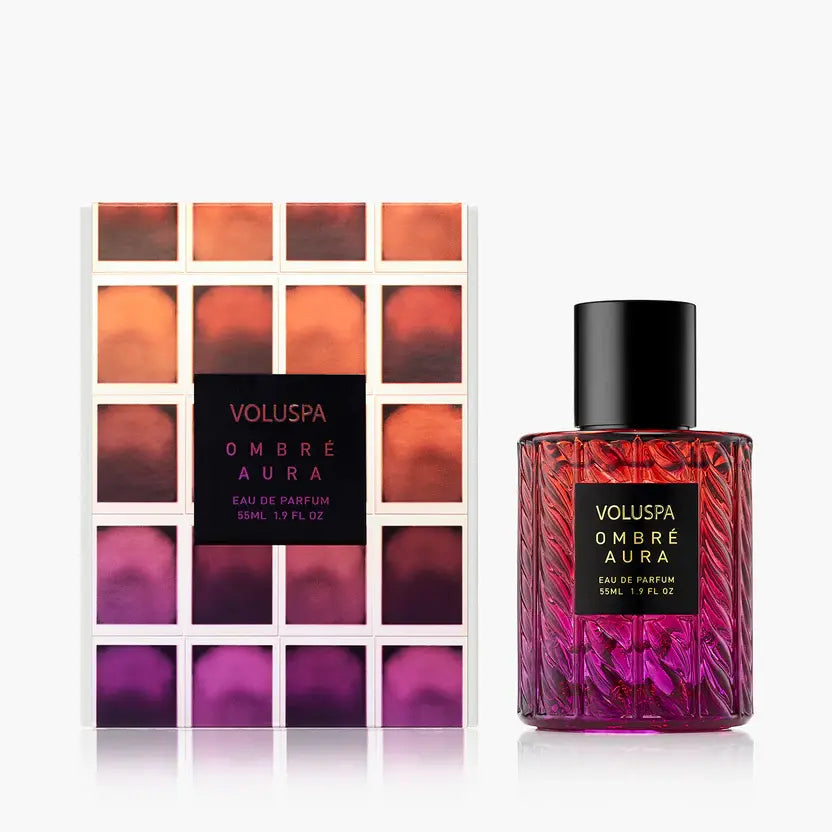 Glass perfume bottle with Ombre Aura label featuring pomegranate, patchouli, and warm amber notes.