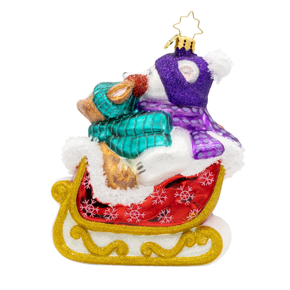 Glass ornament of a polar bear and reindeer in a red sleigh with gold glitter runners.