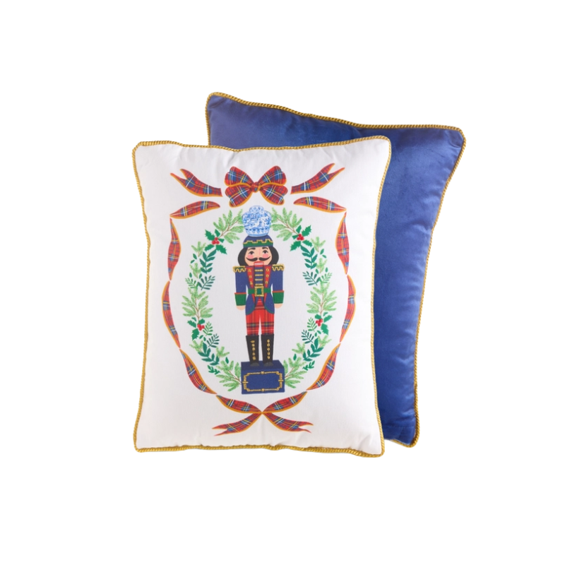 16-inch white pillow with a nutcracker in a wreath and a blue velvet back with gold trim.