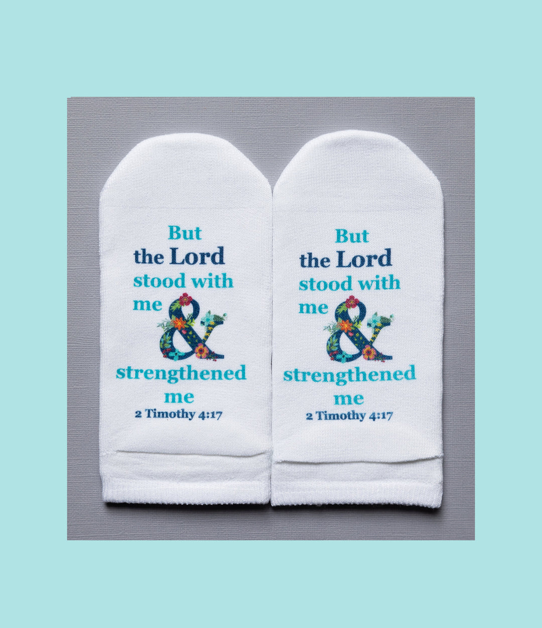 White no-show socks featuring the Bible verse 2 Timothy 4:17 with a floral ampersand design.