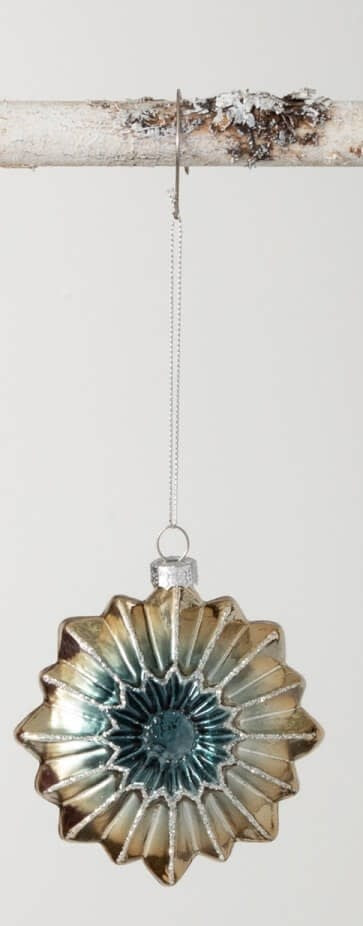 Star-shaped glass witch eye ornament with a blue center and metallic gold, ribbed petals.