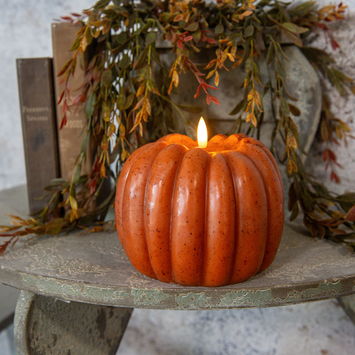 Orange plastic pumpkin candle with realistic wax flame effect