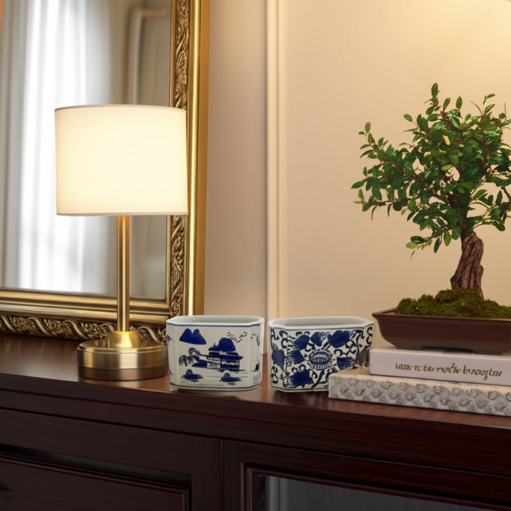 Two blue and white ceramic rectangle pencil cups with traditional patterns on a wooden surface.