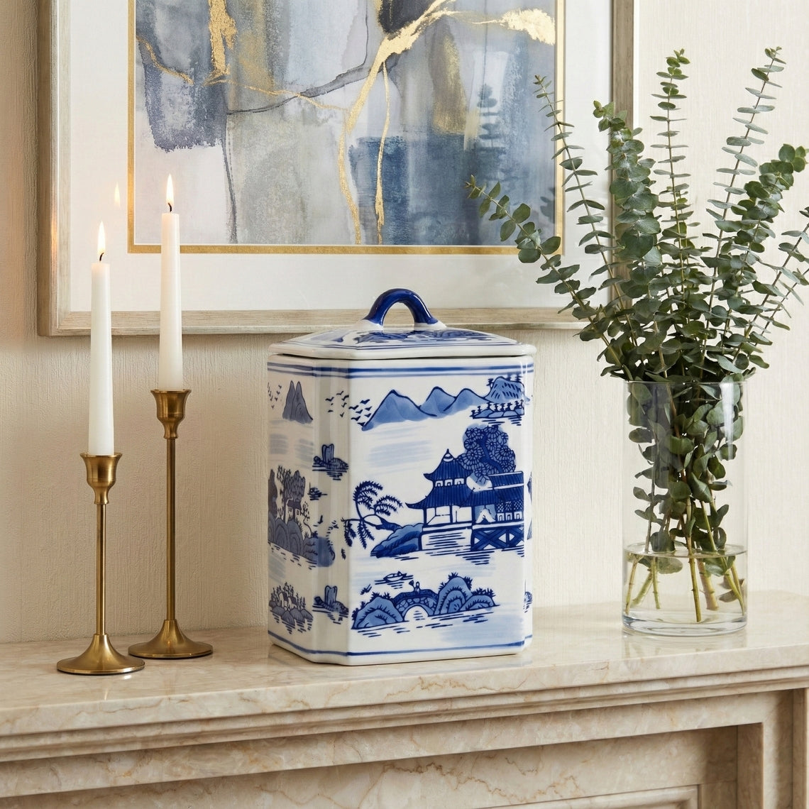 8 in. Blue Ceramic Rectangular Lidded Decorative Jar with a landscape scene on a mantel.