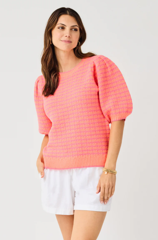 Woman wearing the Abigail Sweater, a pink and orange striped knit top with puff sleeves.
