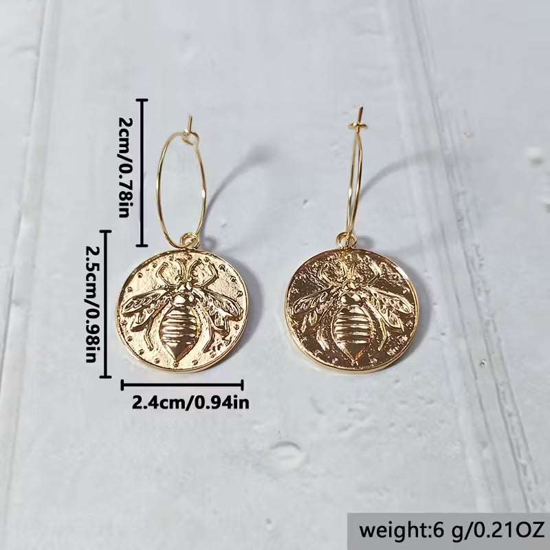 Boho-Chic gold-tone round pendant earrings with bee pattern and oversized wire hoops.