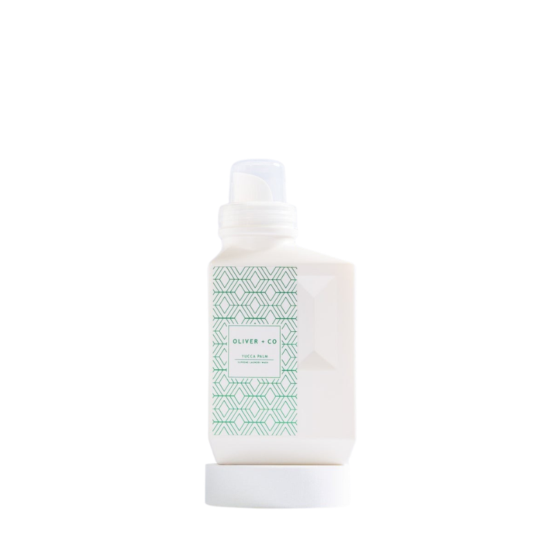Oliver + Co Yucca Palm Supreme Laundry Wash in a white bottle with a green geometric label.