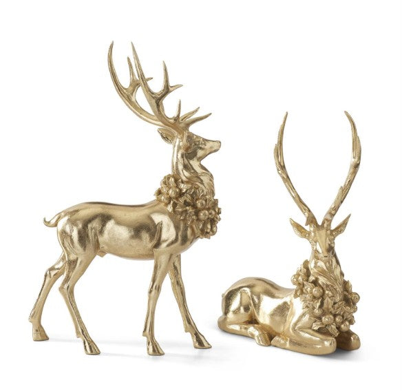 Set of two gold resin deer figurines, one standing and one resting, with wreaths around their necks.