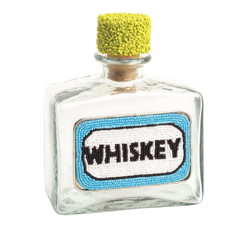 Glass whiskey decanter with a blue and white beaded label and a yellow beaded cork stopper.