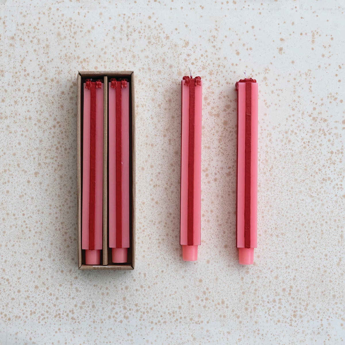 Four pink unscented taper candles shaped like tall gift packages with red ribbon details.