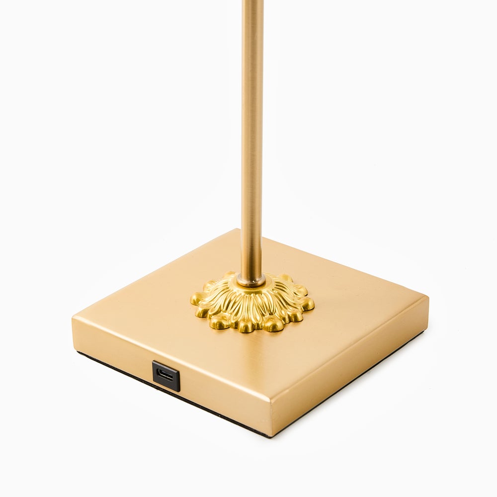 Close-up of a gold square lamp base with a USB-C charging port and decorative fluted stem detail.