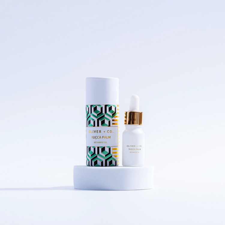 Oliver + Co. Yucca Palm Recharge Oil in a white dropper bottle next to its patterned tube packaging.