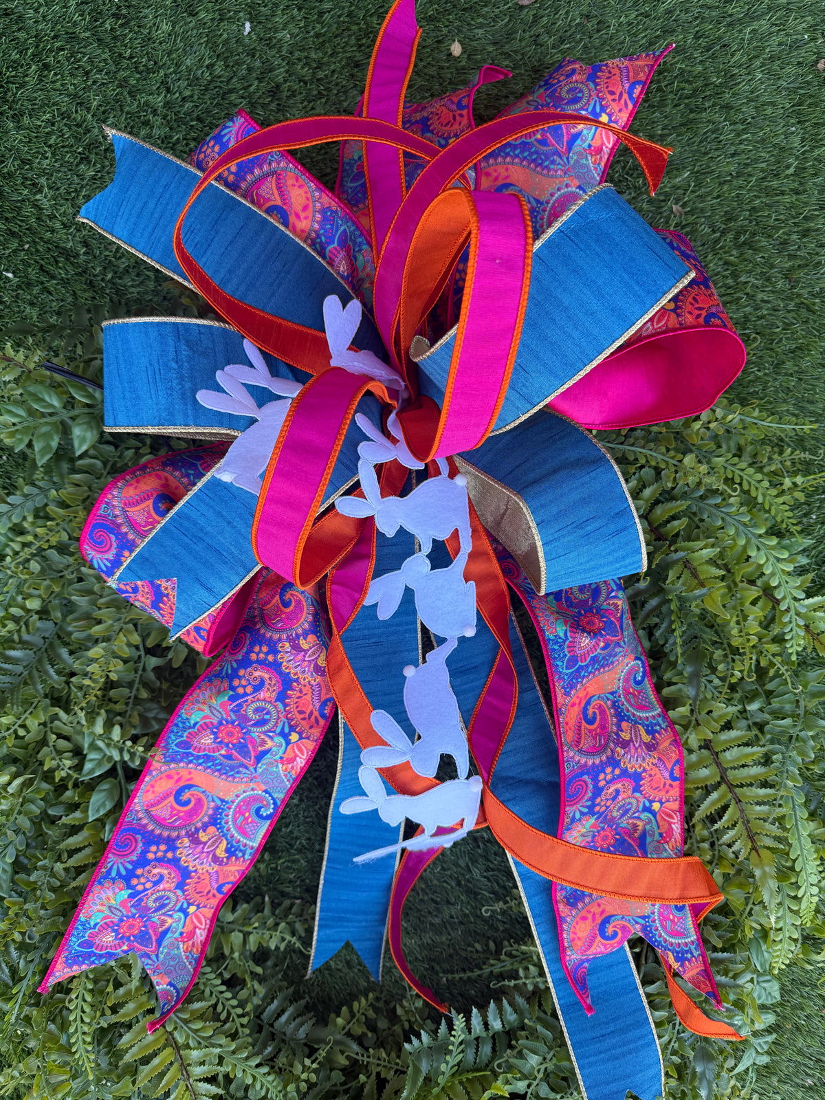 Brightly colored Easter bow with white bunny cutouts and paisley ribbon.