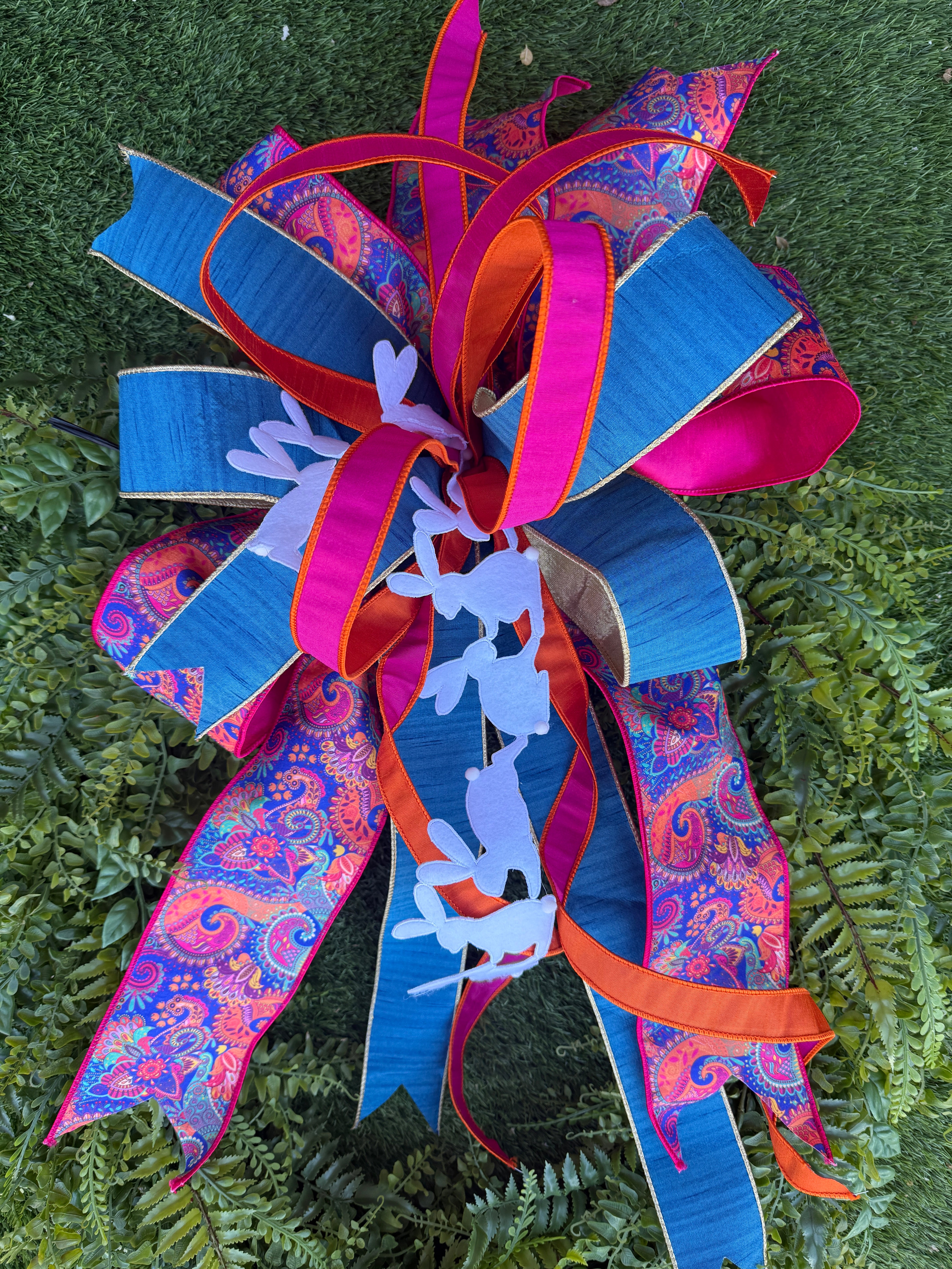 Brightly colored Easter bow with white bunny cutouts and paisley ribbon.