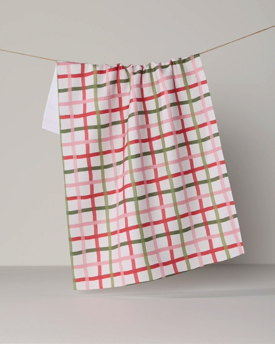 Everyday Tea Towel with a red, pink, and green plaid pattern hanging on a clothesline.
