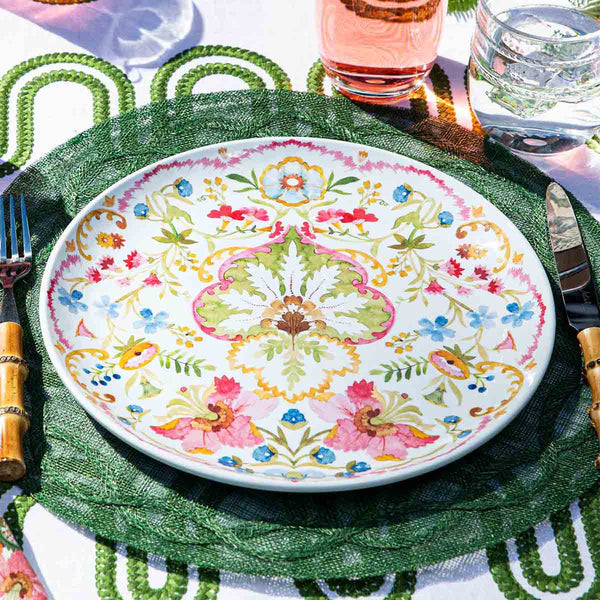 Sofia Melamine Dinner Plate with a colorful floral and damask pattern on a green placemat.