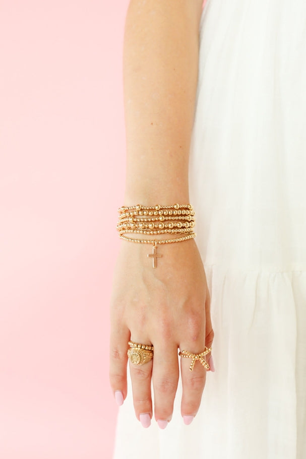 Elastic bracelet with 14K gold filled beads and a hollow light weight charm.