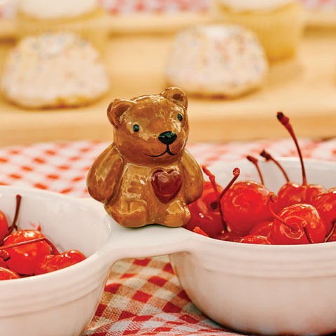 Hand-painted brown ceramic teddy bear mini with a red heart, perched on a white serving dish.