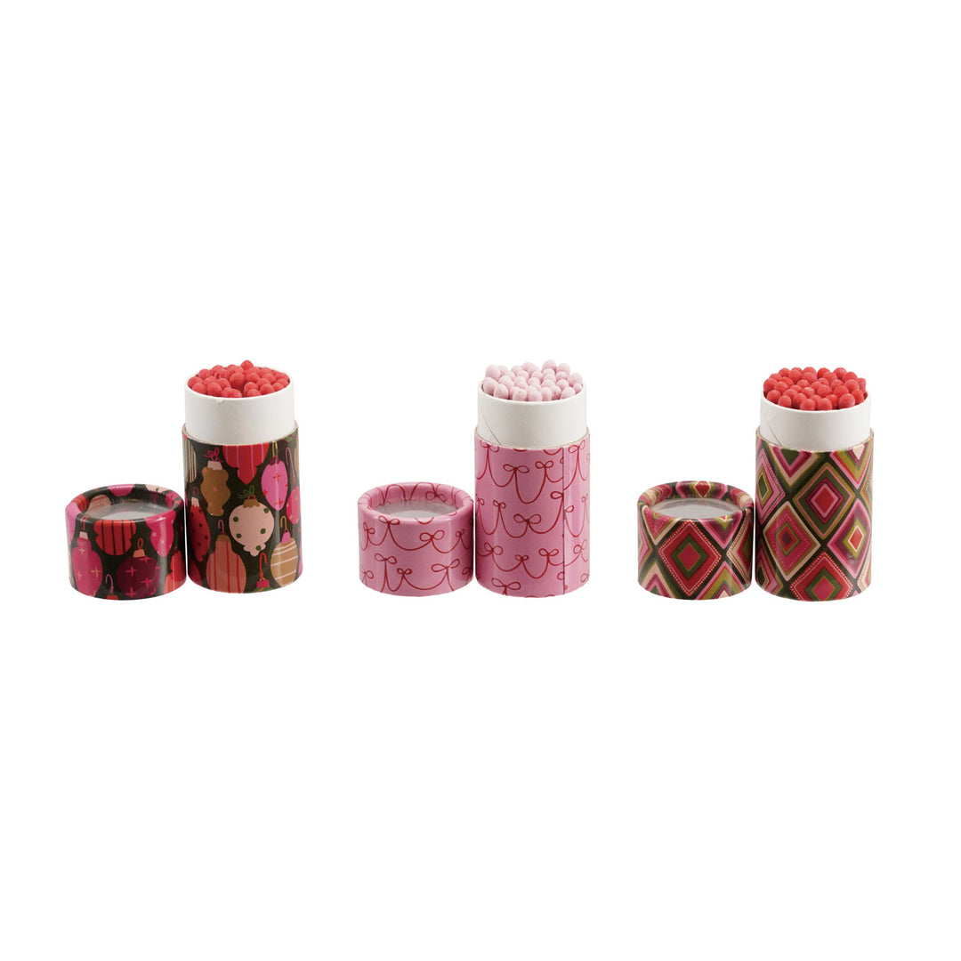 Three sets of safety matches in decorative holiday-patterned tubes with matching lids.
