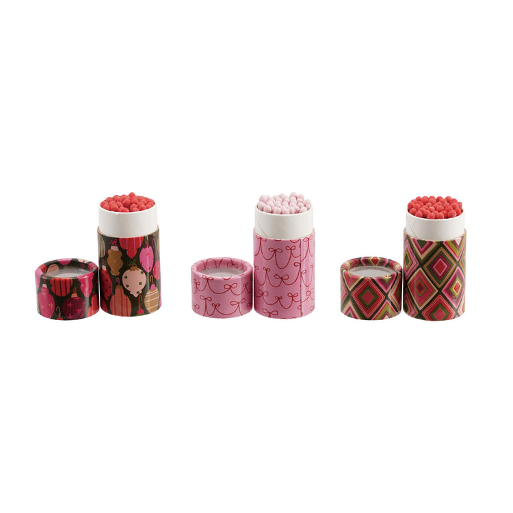 Three sets of safety matches in decorative holiday-patterned tubes with matching lids.