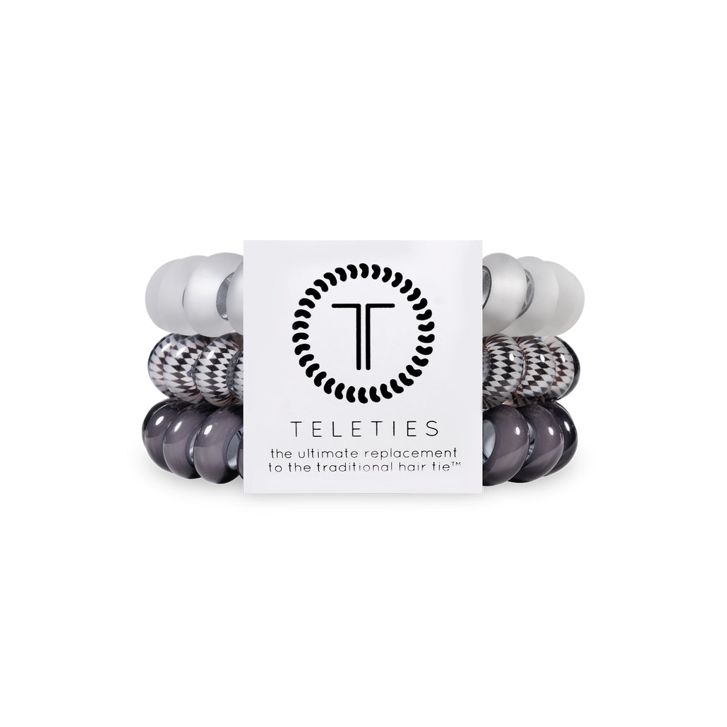 Three large black spiral hair coils with a bracelet-style grip.