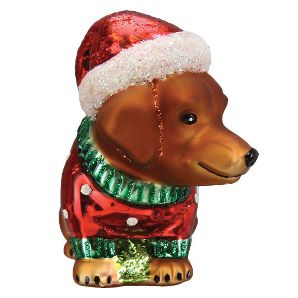 Dashing Dachshund puppy glass ornament wearing a red Santa hat and a red and green holiday sweater.