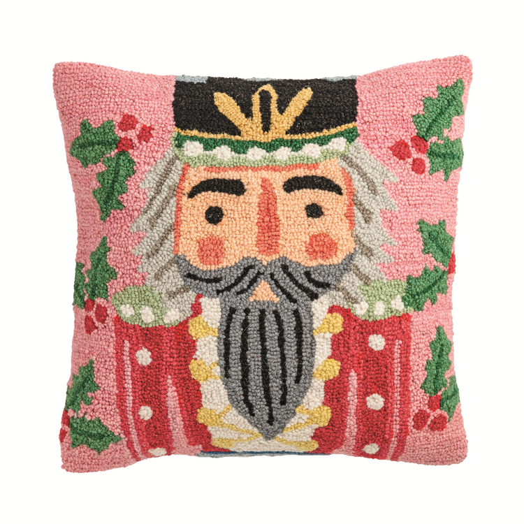 Two hooked wool nutcracker pillows with a red face, black hat, and white beard on a neutral background.