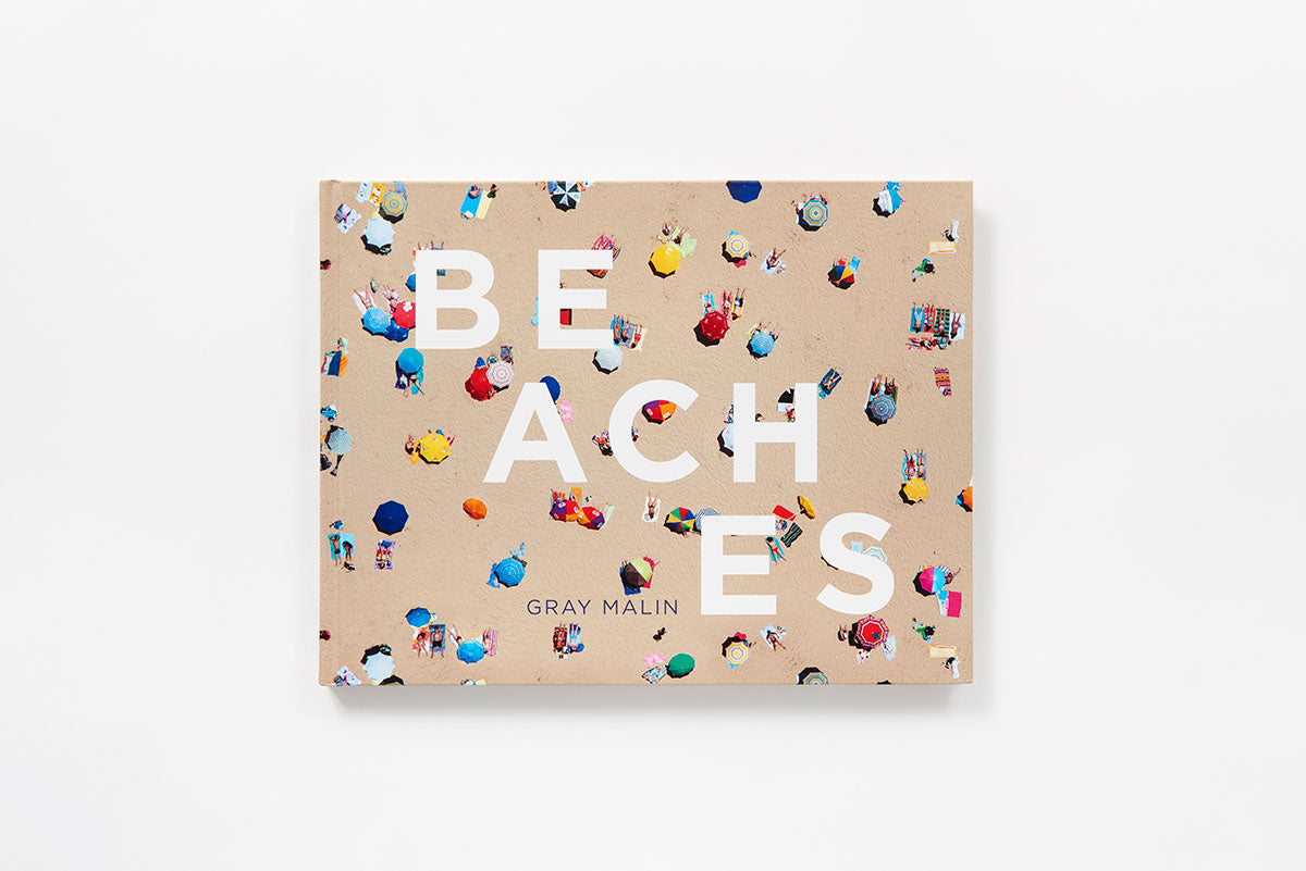 Gray Malin's 'Beaches' book cover, featuring an aerial view of a sandy beach with colorful umbrellas and people.