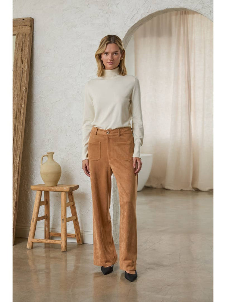 Woman wearing tan Lucy faux suede wide leg pants with front pockets and a cream turtleneck.