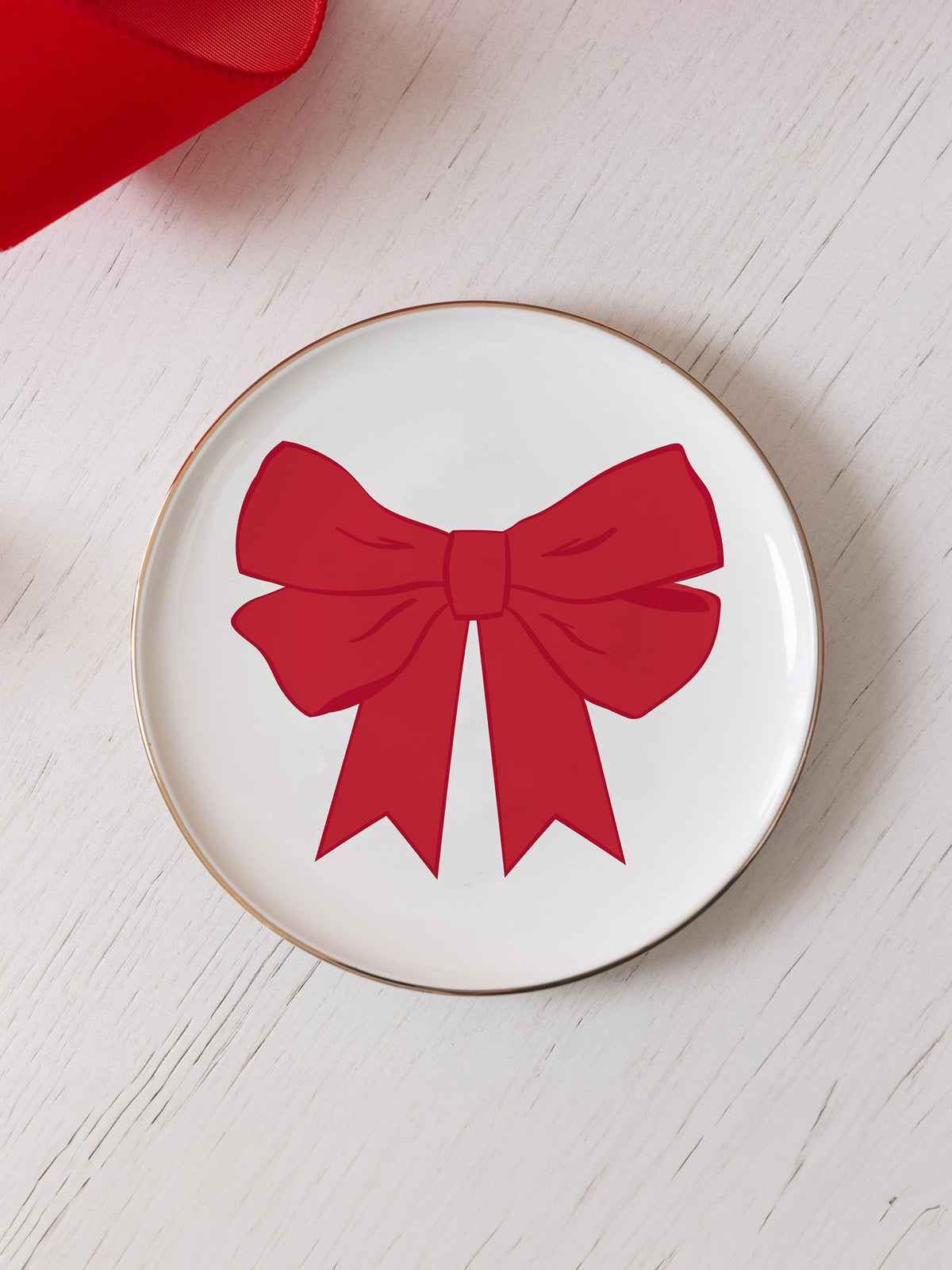 6-inch white ceramic appetizer plate with a red bow design and gold foil trim.