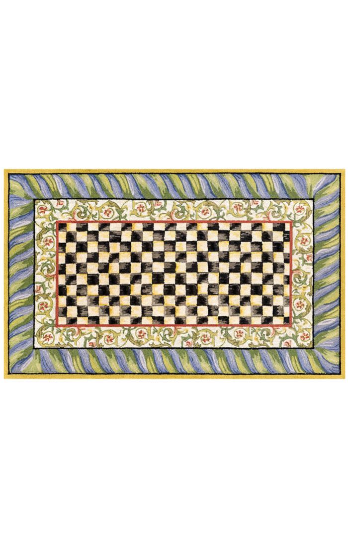 Rectangular washable rug with a black and white checkered center and purple and green floral border.