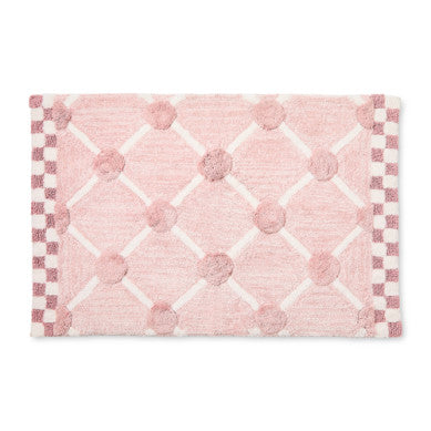 Handmade cotton bath rug with a lattice and dot pattern in neutral tones.