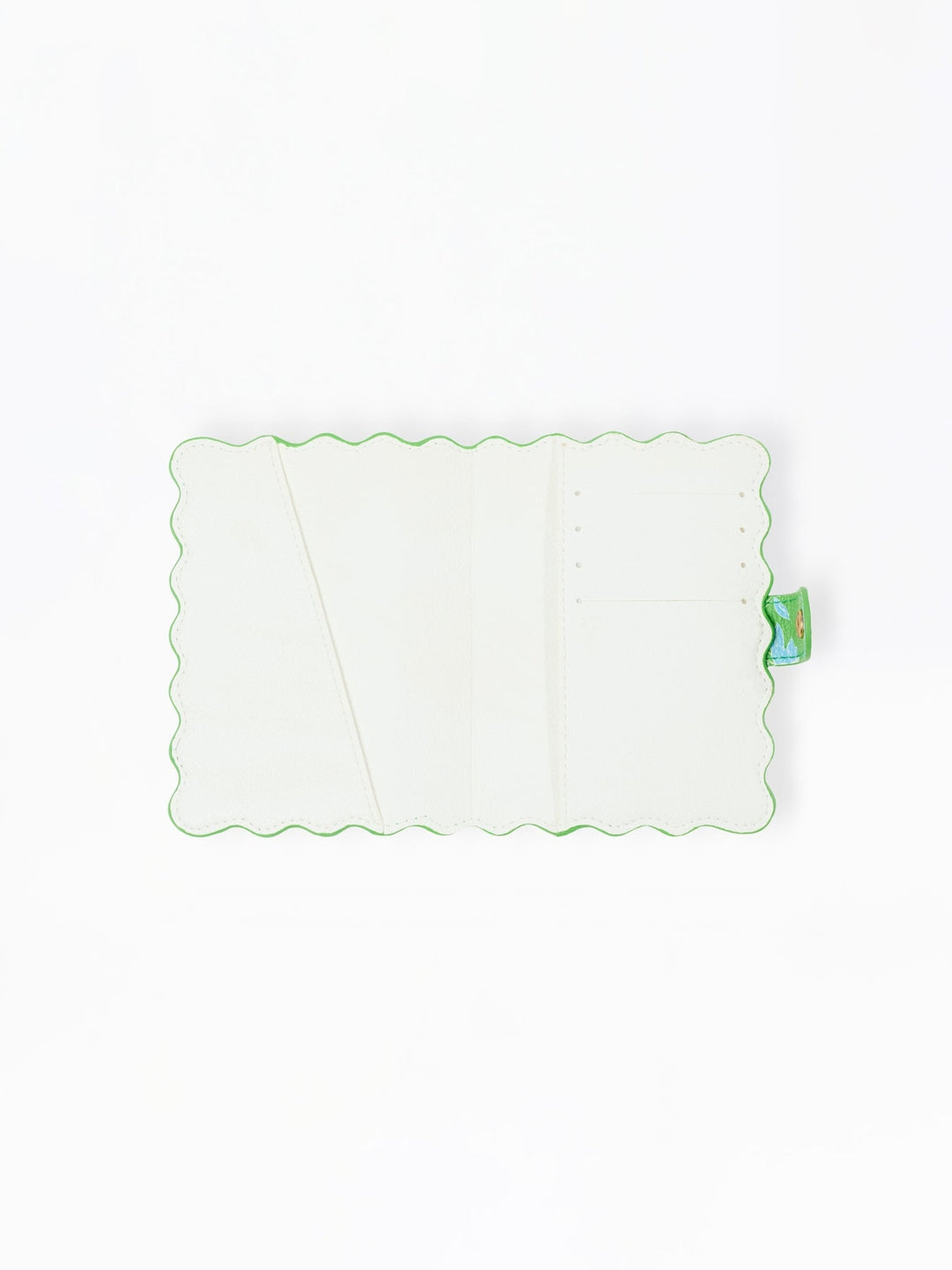 Open interior of a white vegan leather passport cover with scalloped green edges and card slots.