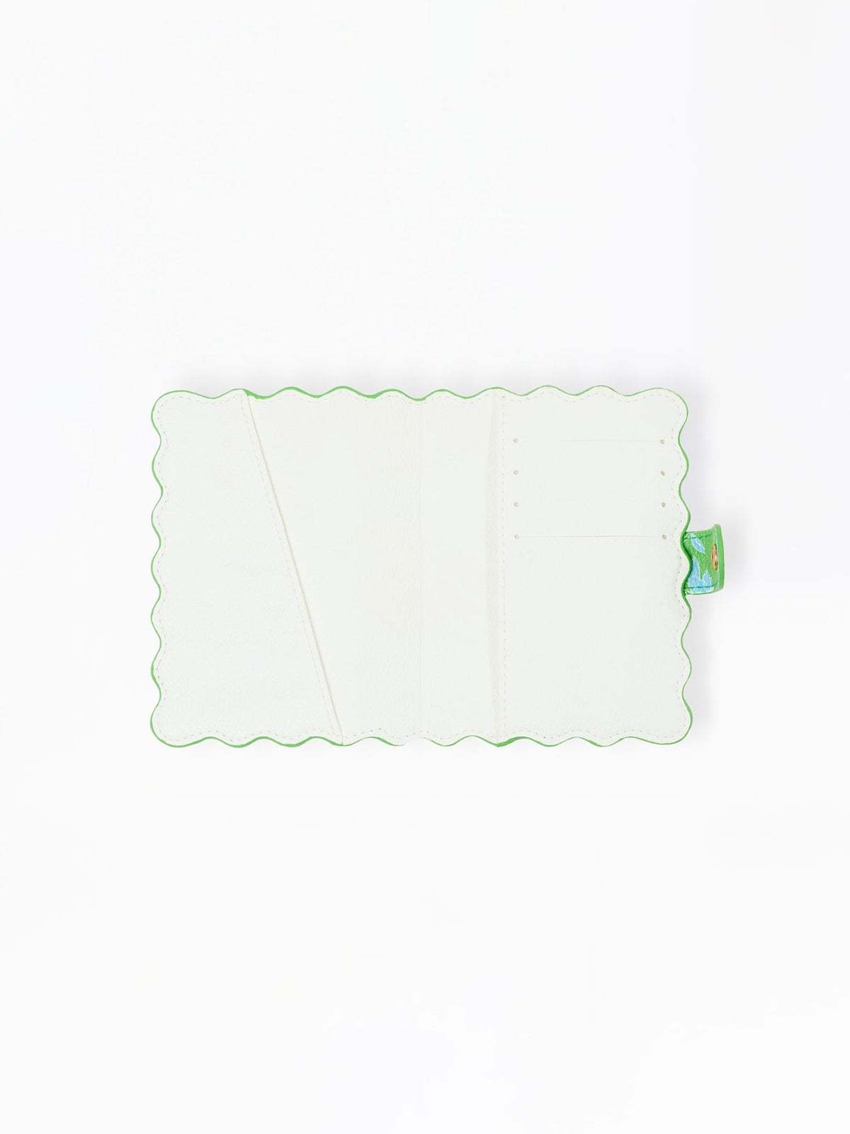 Open interior of a white vegan leather passport cover with scalloped green edges and card slots.