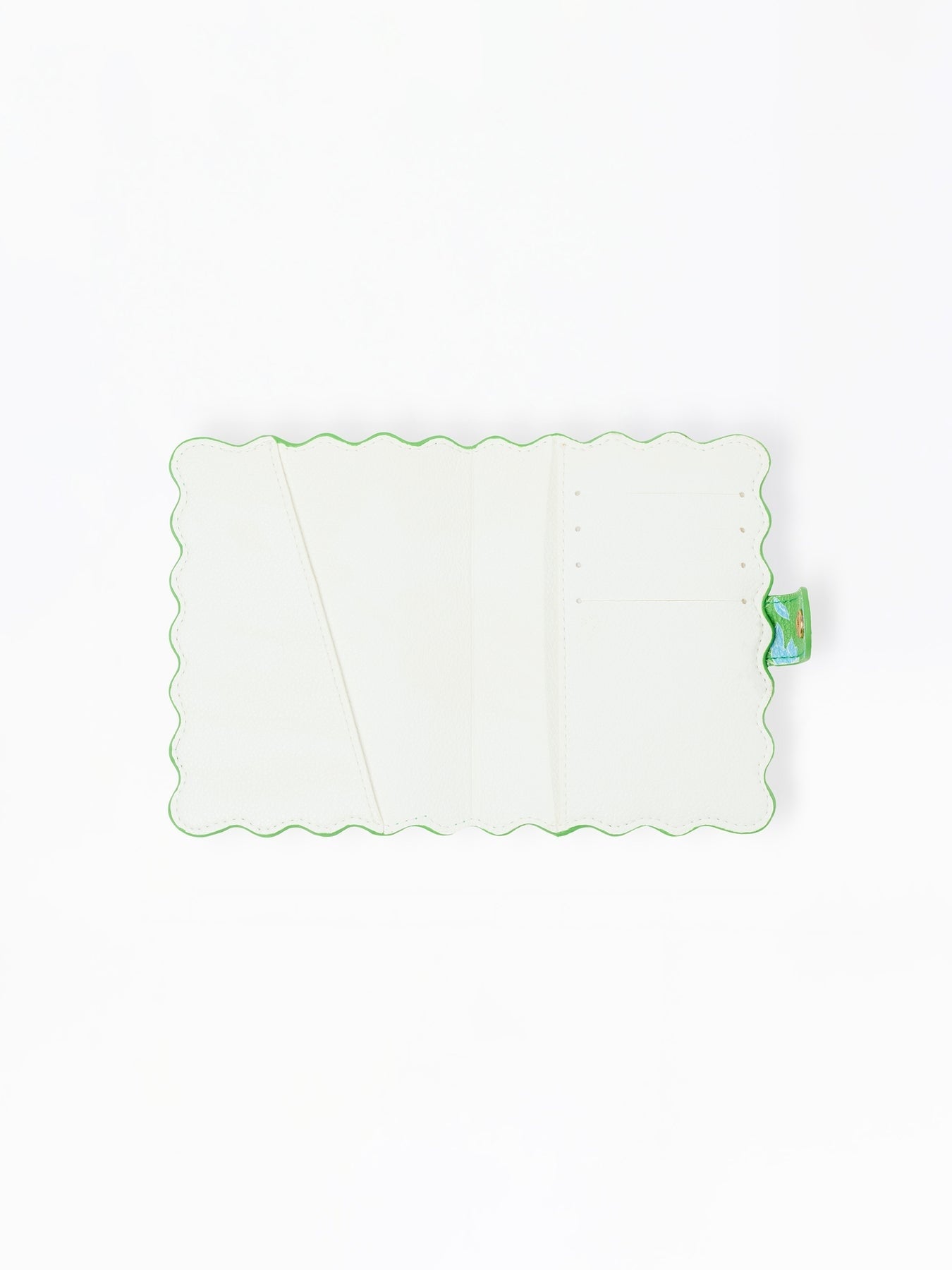 Open interior of a white vegan leather passport cover with scalloped green edges and card slots.