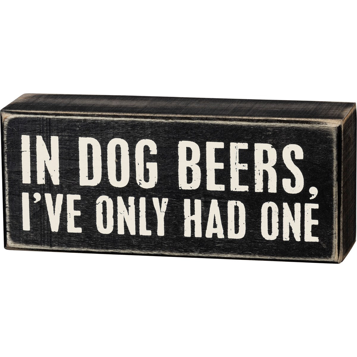 Black wooden box sign with white text reading 'IN DOG BEERS, I'VE ONLY HAD ONE'.