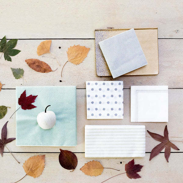 Pack of twenty white spunlace dot-pattern cocktail napkins folded square.