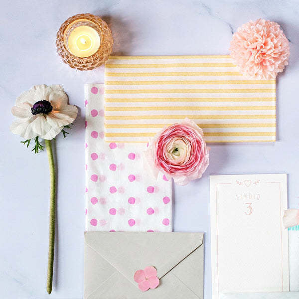 Pack of twenty white spunlace guest towels with a dot pattern.