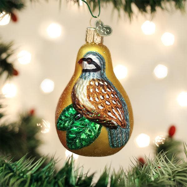 Partridge in a Pear ornament featuring a partridge perched on a pear branch with green leaves.