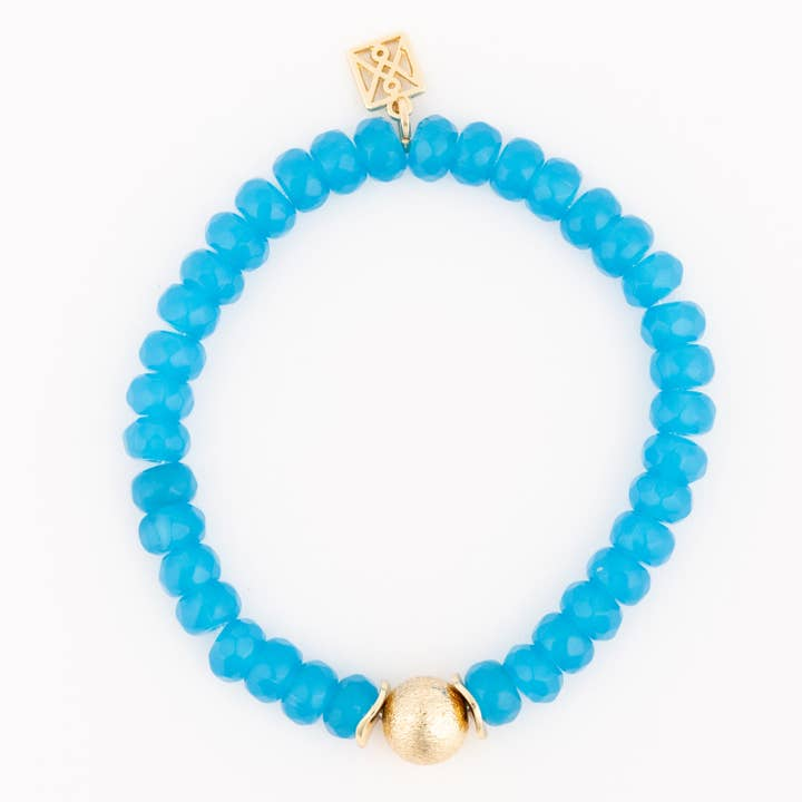 Paloma Blue beaded bracelet with faceted blue beads, a gold textured bead, and a gold logo charm.
