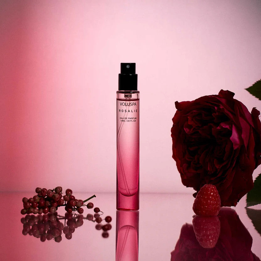 Voluspa Rosalie 10ml Eau De Parfum travel spray bottle with a rose, raspberry, and pink peppercorns.