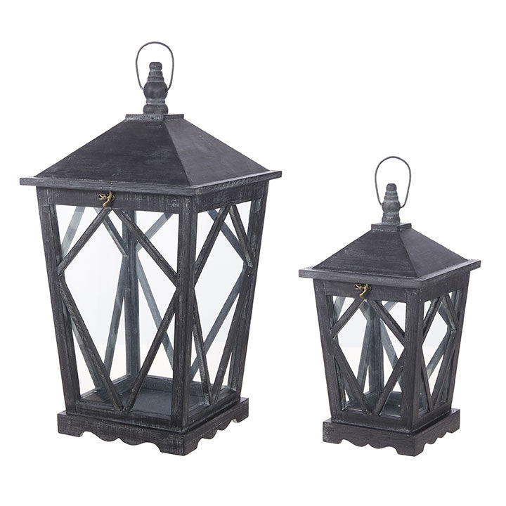 Set of two black washed wooden lanterns with glass panels and decorative lattice design.