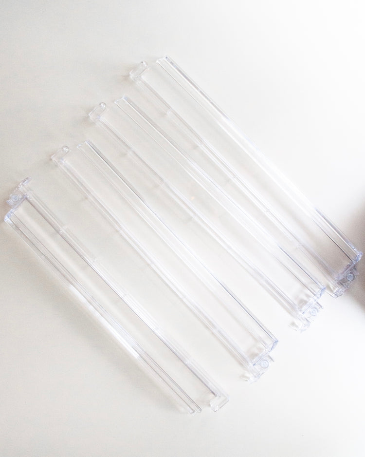 Set of four clear acrylic racks with pushers featuring an 18.25-inch stack length.