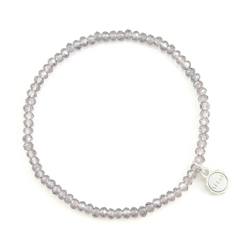 Lizas Quadro Big crystal stretch bracelet in smoky grey with a silver-tone logo charm.