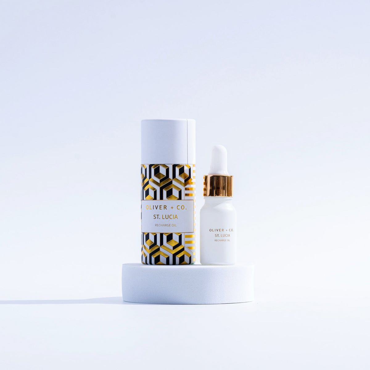 Oliver + Co. St. Lucia Recharge Oil in a white dropper bottle next to its patterned cylinder box.