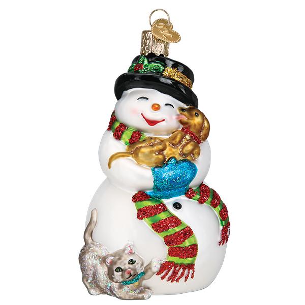 Glass snowman ornament wearing a black hat and striped scarf, holding a puppy and a kitten.