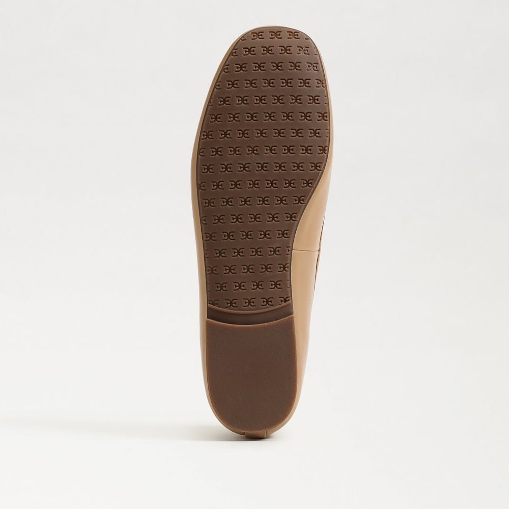 Bottom view of the Alie Ballet Flat showing a brown rubber sole with a repeating logo pattern.