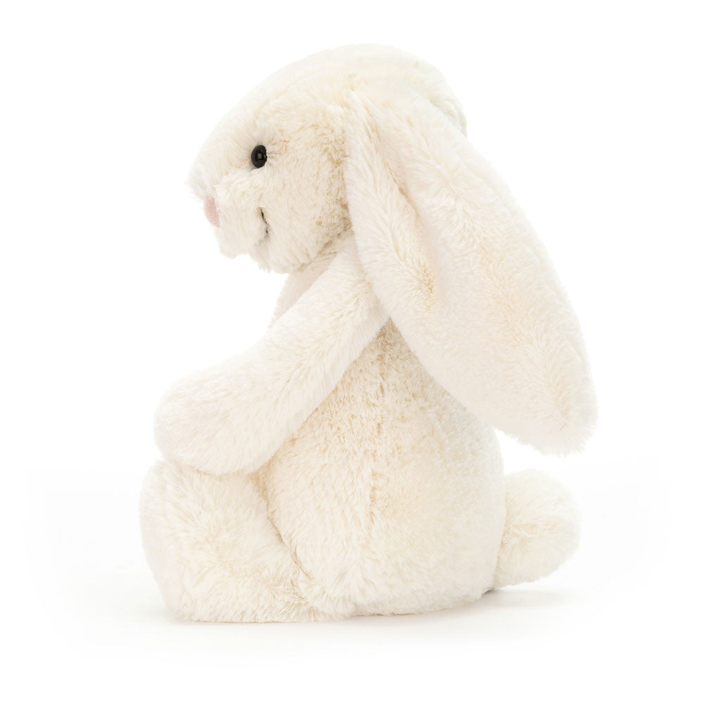 Side view of a Bashful Cream Bunny plush toy with long floppy ears and a soft cream-colored coat.