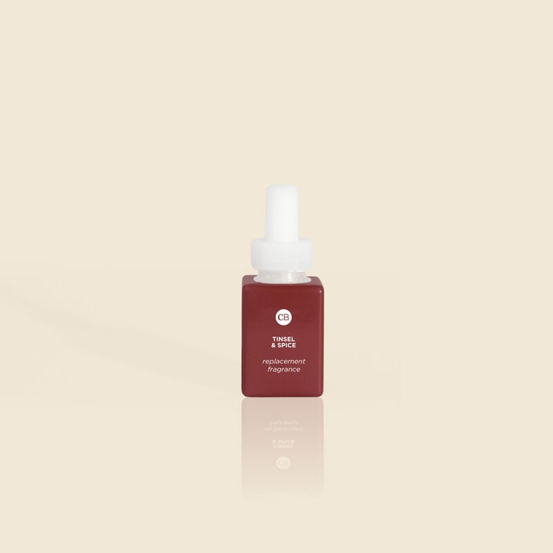 Tinsel & Spice Pura Diffuser refill vial with neutral-colored liquid inside.
